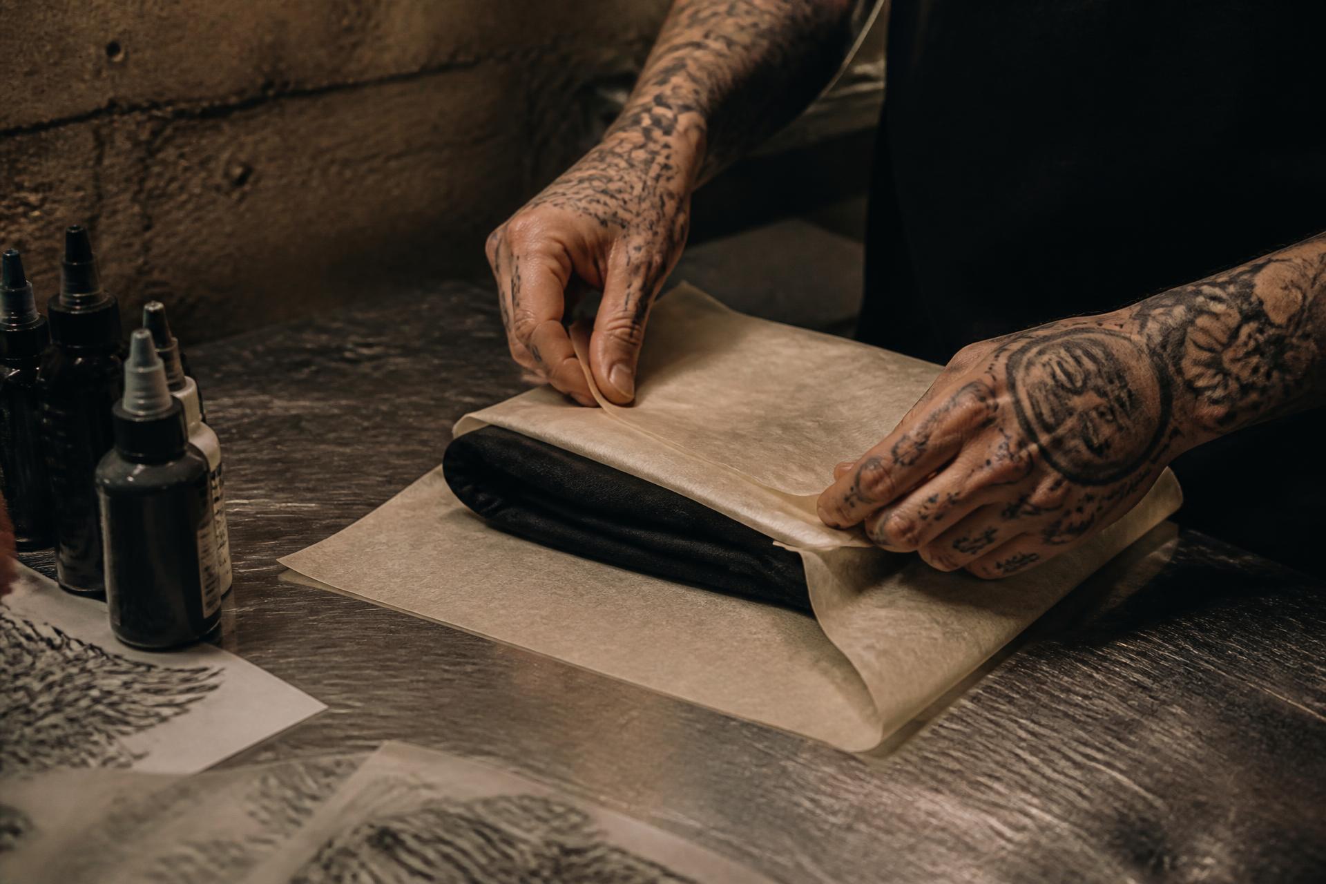 An Inkspace artist wrapping a screen-printed piece by hand at the studio workbench